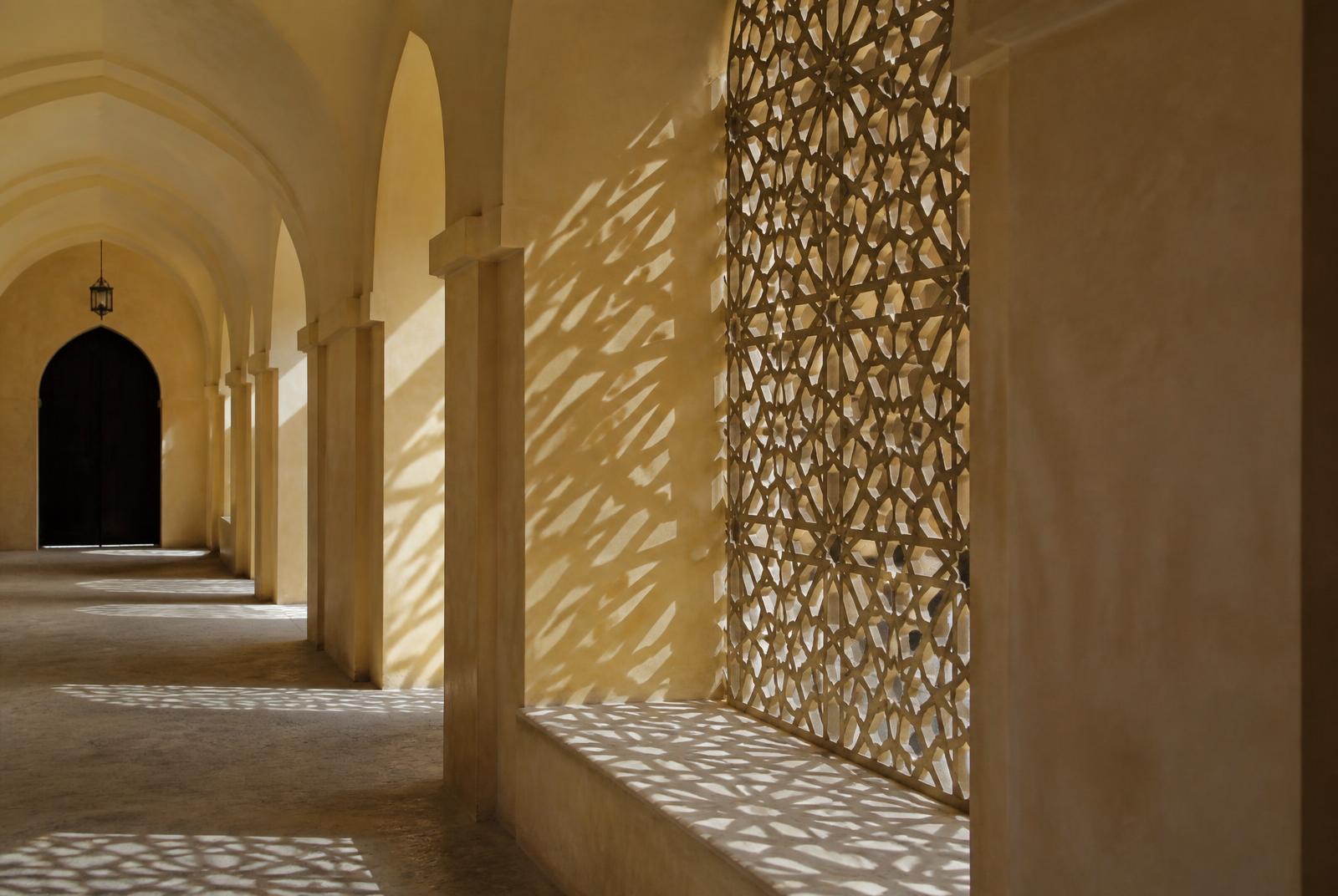 Arched plaster hall with carved geometric screens
