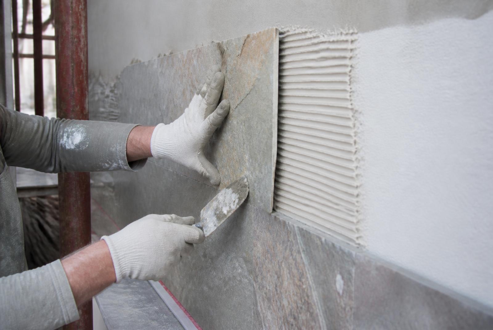 Flexible stone tile being applied to a wall